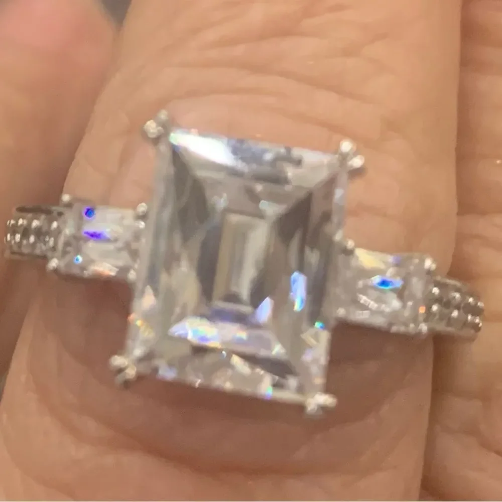 Lovely emerald cut solitaire with a pretty ring guard . Size 9 . Rhodium plated